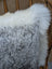 A cozy gray and white merino sheepskin cushion with plush faux fur texture by angus oliver canada