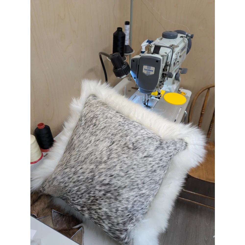 A plush gray and white merino sheepskin cushion with soft fluffy white fur trim by angus oliver canada