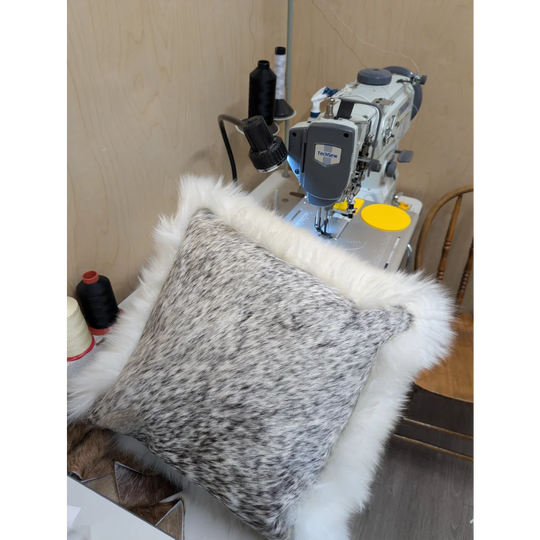 A plush gray and white merino sheepskin cushion with soft fluffy white fur trim by angus oliver canada