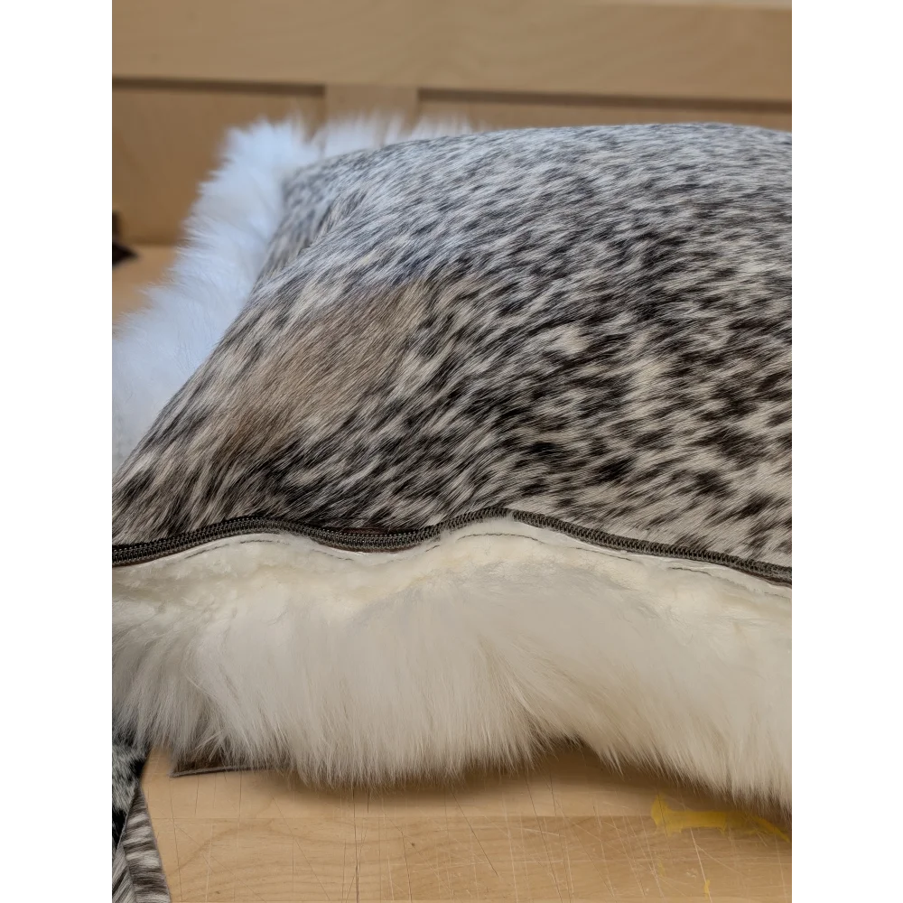A plush gray and white merino sheepskin cushion with soft white faux fur trim by angus oliver canada