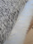 A cowhide and merino sheepskin cushion with black and white speckled faux fur and soft white fabric by angus oliver canada