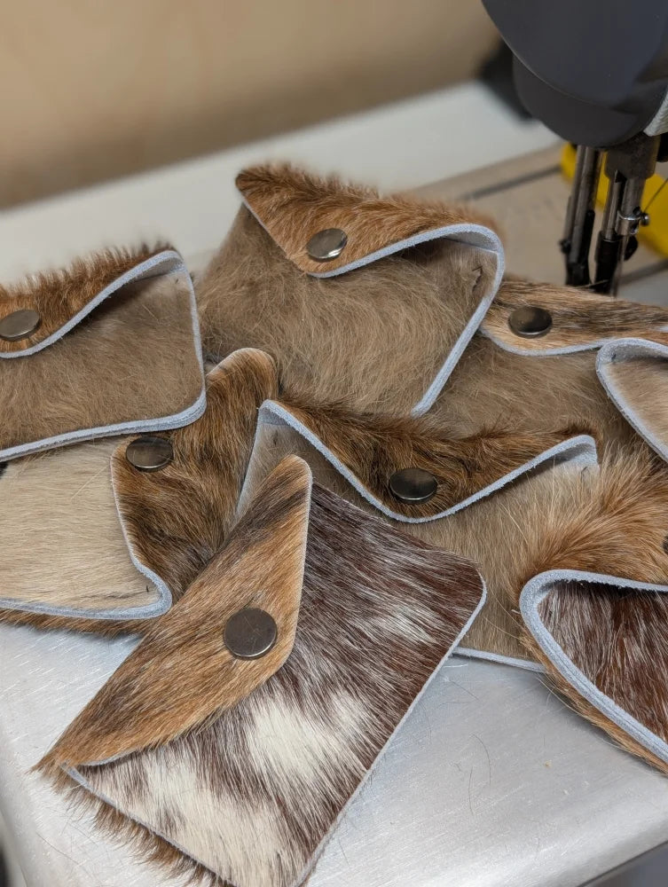 Brown and white cowhide bank card holder with silver snap closure by angus oliver canada, perfect with sheepskin rugs
