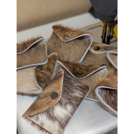 Brown and white cowhide bank card holder with silver snap closure by angus oliver canada, perfect with sheepskin rugs