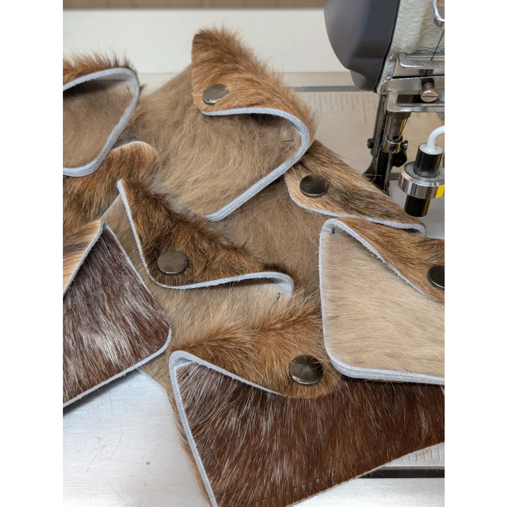 Brown and tan cowhide bank card holders with silver-stitched edges and metallic snap closures by angus oliver canada