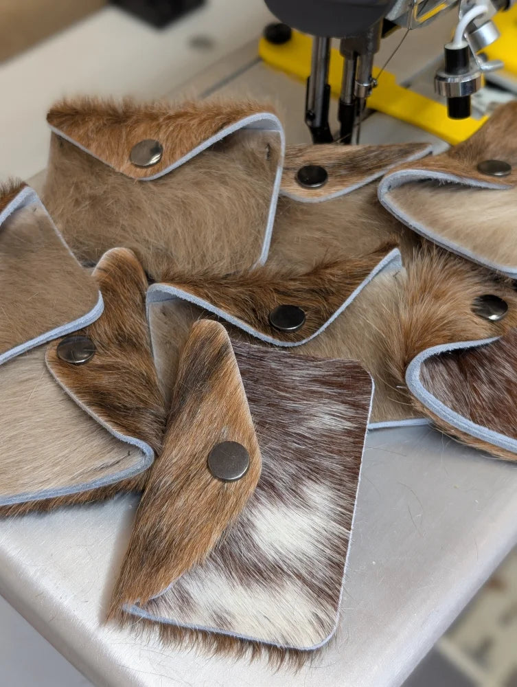 Brown and white cowhide wallet with silver snap closure perfect for angus oliver fans who love canada cowhide rugs