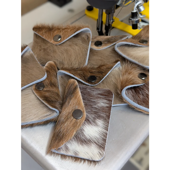 Brown and white cowhide wallet with silver snap closure perfect for angus oliver fans who love canada cowhide rugs