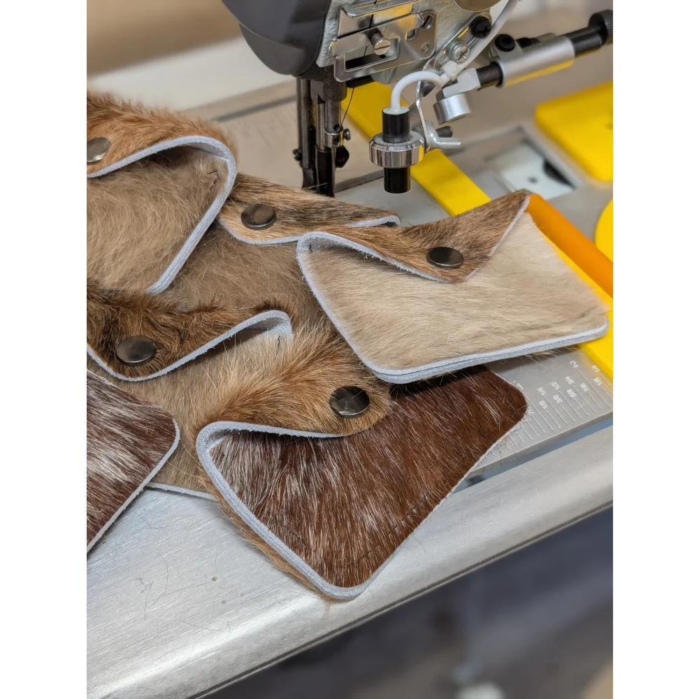 Brown and beige cowhide bank card holders with silver stitch edges and black snaps by angus oliver canada