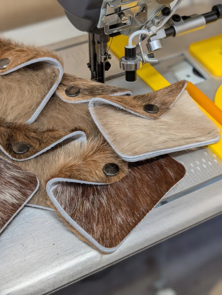 Brown and beige cowhide bank card holders with silver stitch edges and black snaps by angus oliver canada