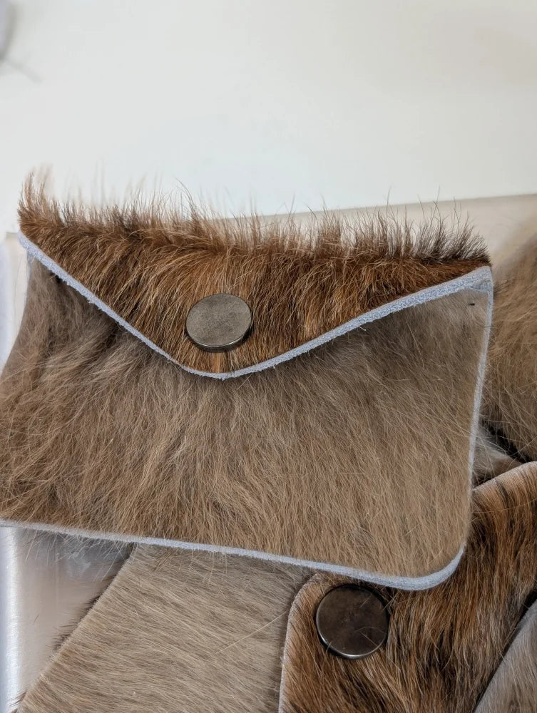 Brown fur cowhide bank card holder with silver button closure and light gray stitch trim by angus oliver canada