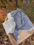 Cream woolen calgary cardigan soft fleece jacket in cozy gray with ribbed knit collar resting in woven basket