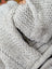 Close-up of cream woolen calgary cardigan with light gray chunky-knit zealand wool and soft fleece zipper pull detail