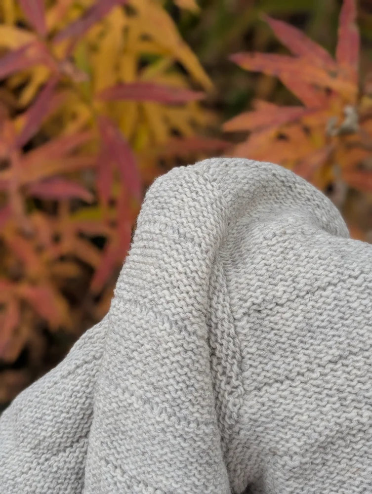 A soft light gray calgary cardigan made from zealand wool with a textured ribbed pattern and soft fleece feel