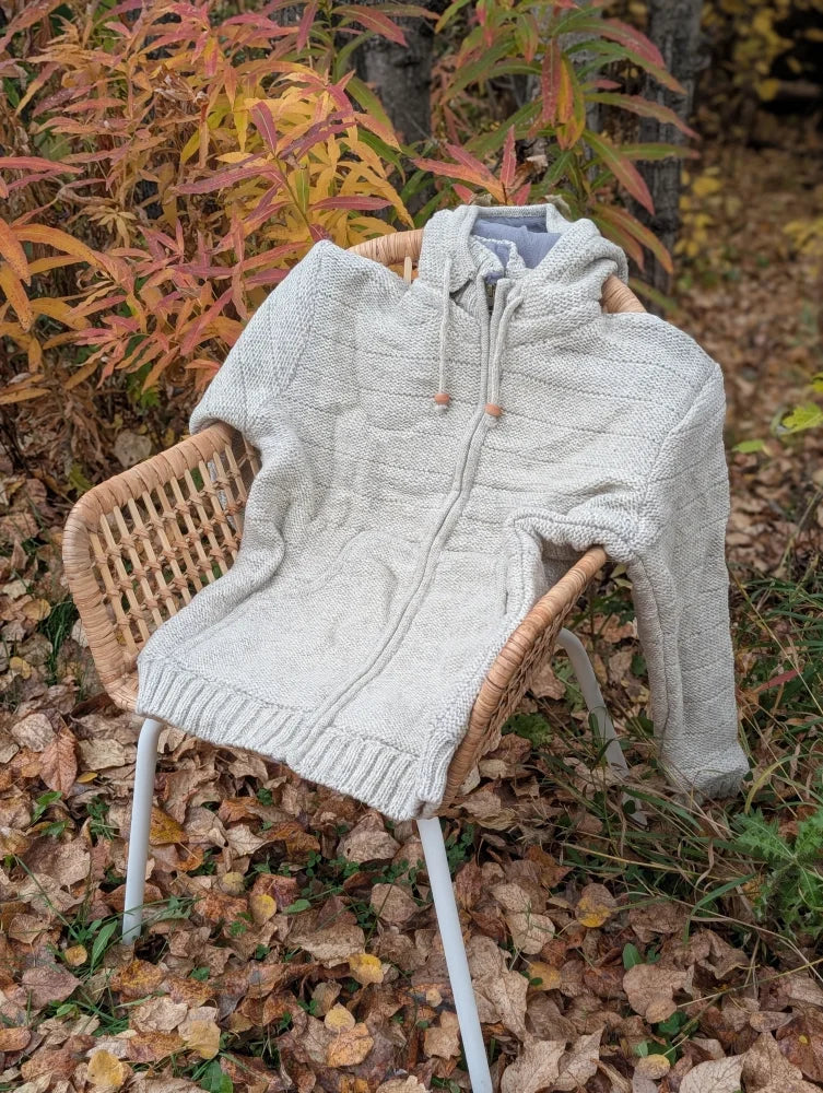 A cozy cream woolen calgary cardigan with light gray zealand wool, soft fleece lining, cable-knit pattern, and wooden toggles