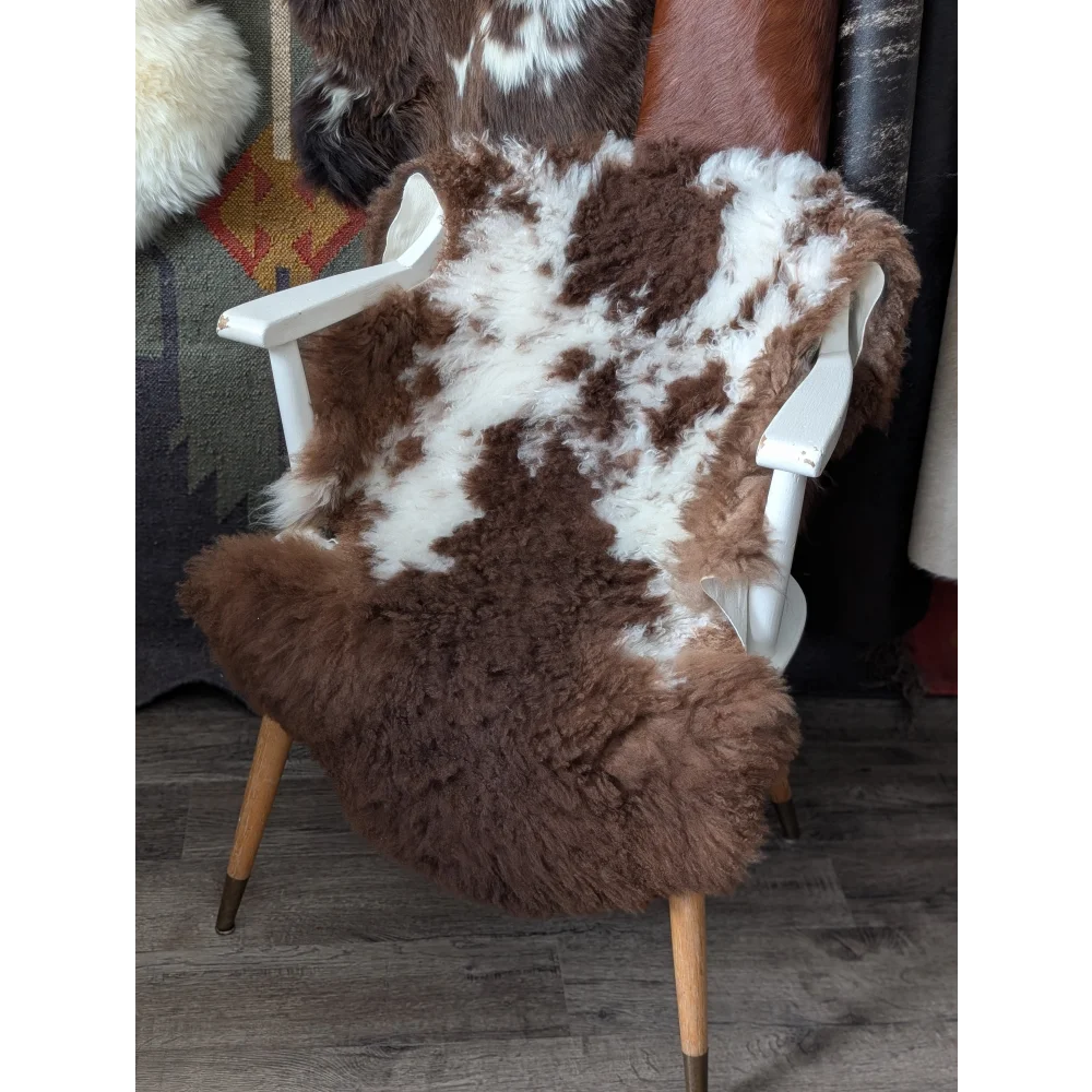 Fluffy cloud oeko tex sheepskin rug in natural colours on white chair