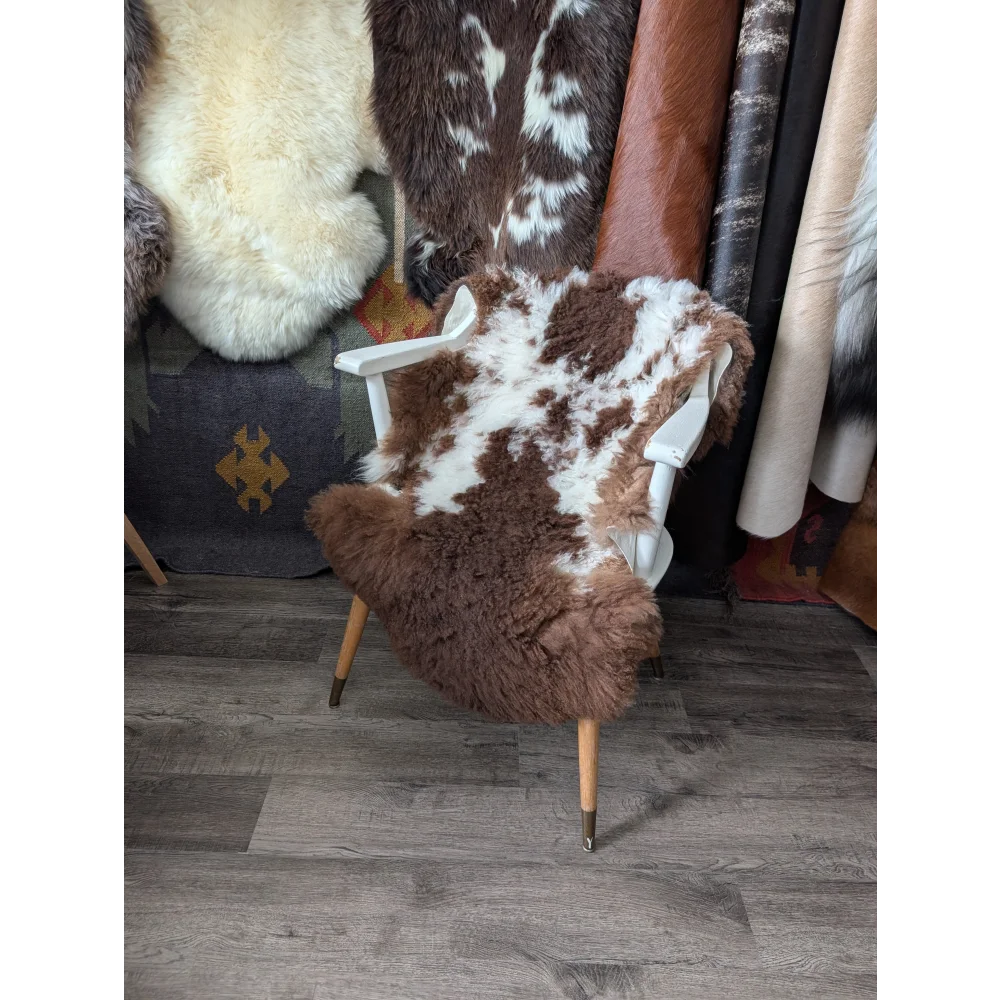 Fluffy cloud Oeko-Tex cowhide rug in natural colours on white chair