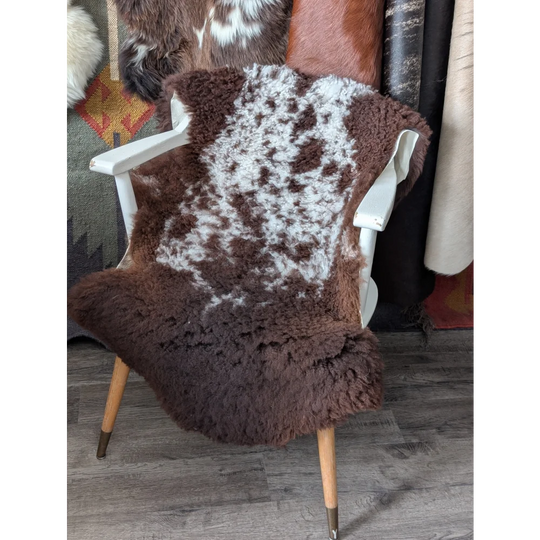 Fluffy cloud oeko tex sheepskin rug in natural colours on white chair