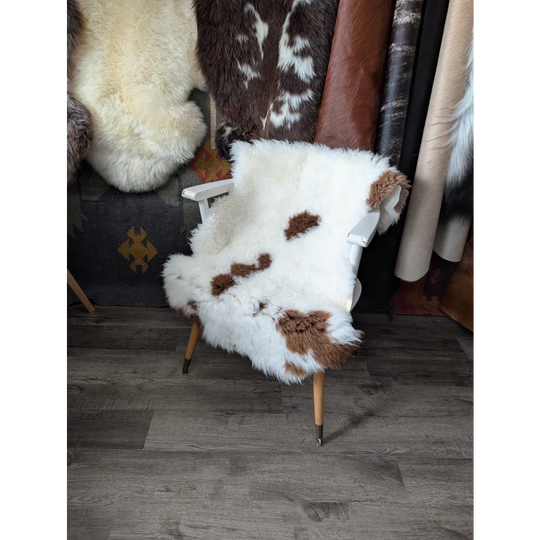 Fluffy cloud grade B sheepskin chair cover in natural colours on armchair