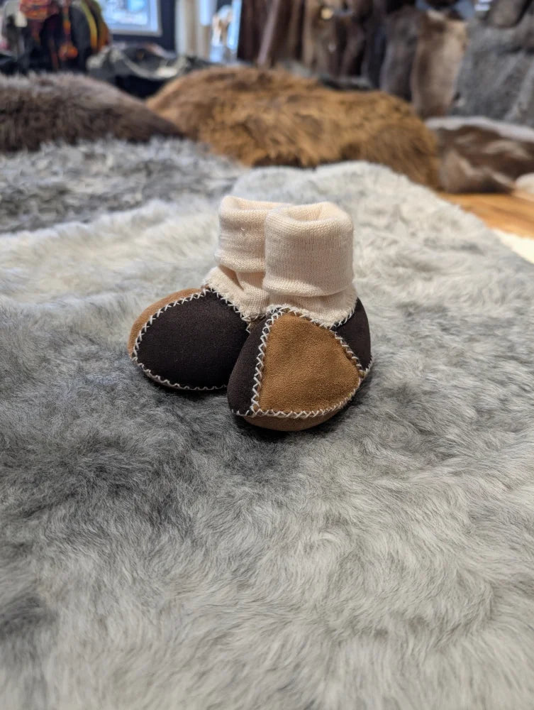 Cute sheepskin baby booties with brown and tan patchwork and stretchy fabric cuff
