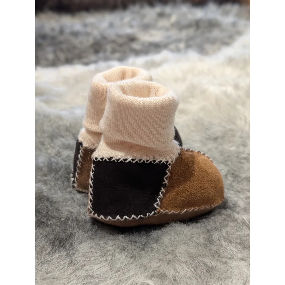 Cute sheepskin baby booties with knitted cuffs and patchwork design in stretchy fabric
