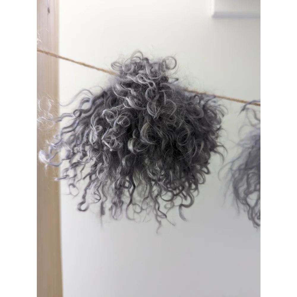 Dark grey sheepskin pom pom with grey curly hair wall decor