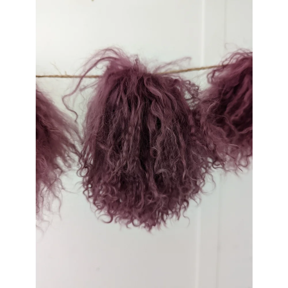 Dark pink sheepskin pom poms with maroon curly hair extension