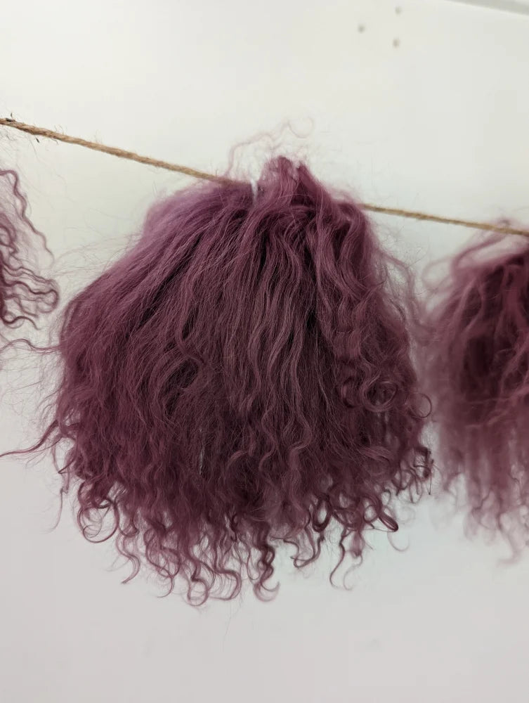 Dark pink curly synthetic hair extensions with sheepskin pom poms