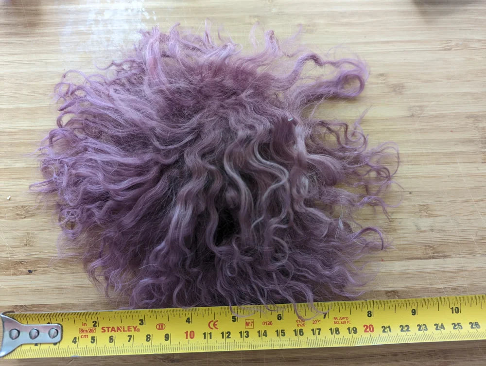 Dark pink sheepskin pom pom with lavender curly wool and ruler scale