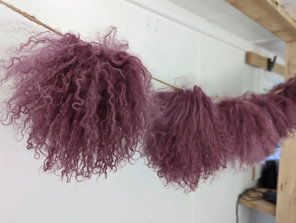 Dark pink sheepskin pom poms with dusty rose curly tulle garland