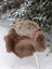 A cozy extra large dark taupe merino sheepskin blanket draped over a wicker chair with white metal legs
