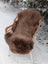 A plush dark taupe merino sheepskin extra large rug draped over a wicker chair for cozy decor