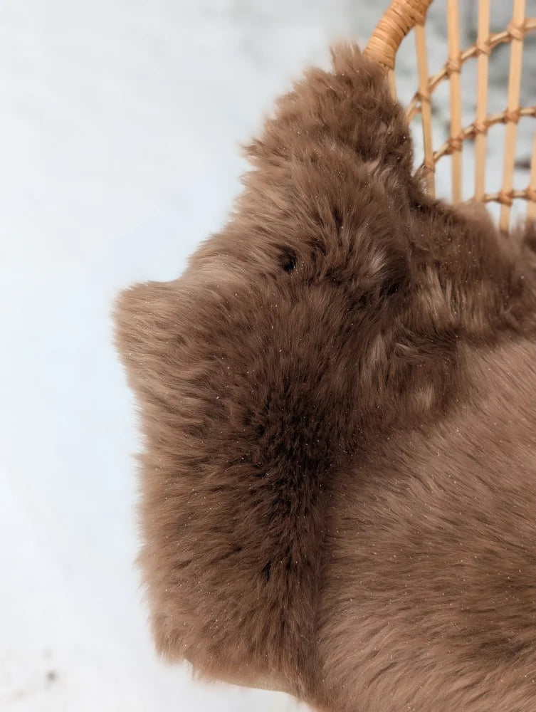 A plush extra large dark taupe merino sheepskin throw with soft fluffy texture and slightly tousled appearance