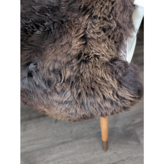 Rare British sheepskin rug, thick curly brown, draped on chair leg