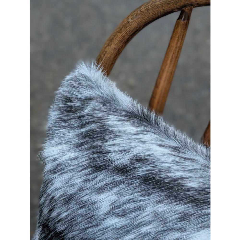 A plush gray and white double sided cowhide cushion with soft textured fur from mini moo double collection
