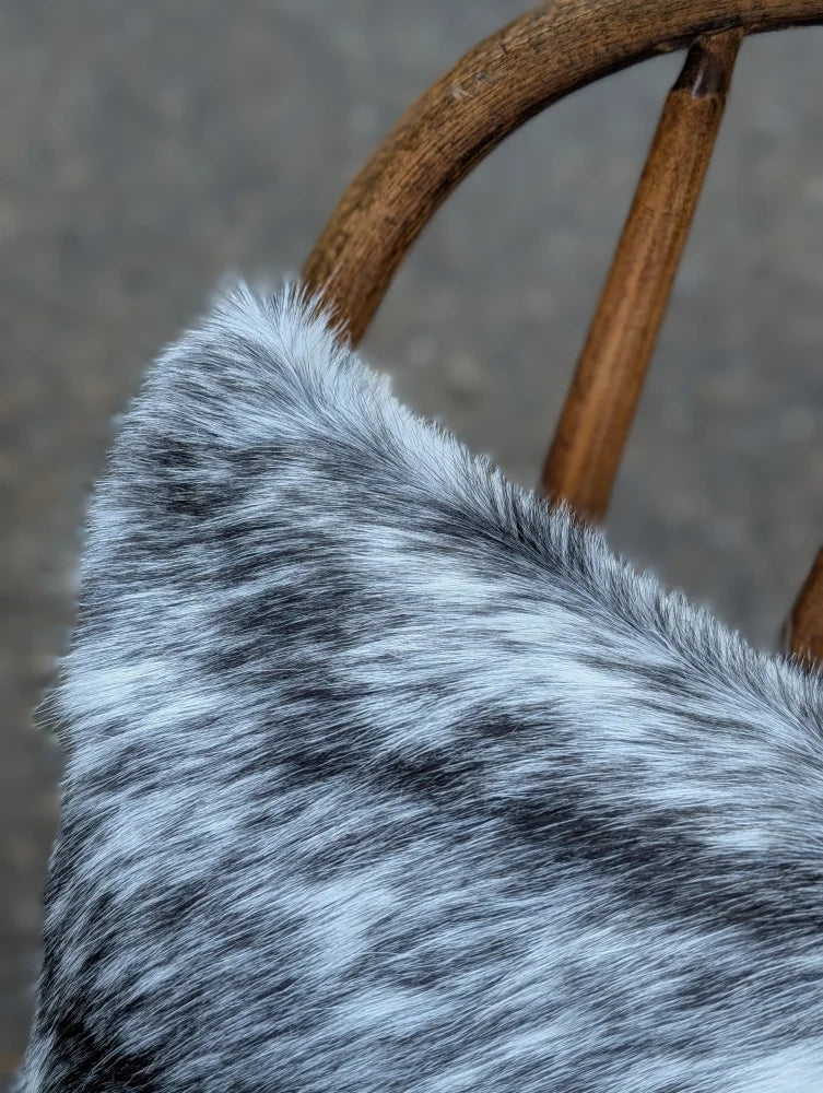 A plush gray and white double sided cowhide cushion with soft textured fur from mini moo double collection