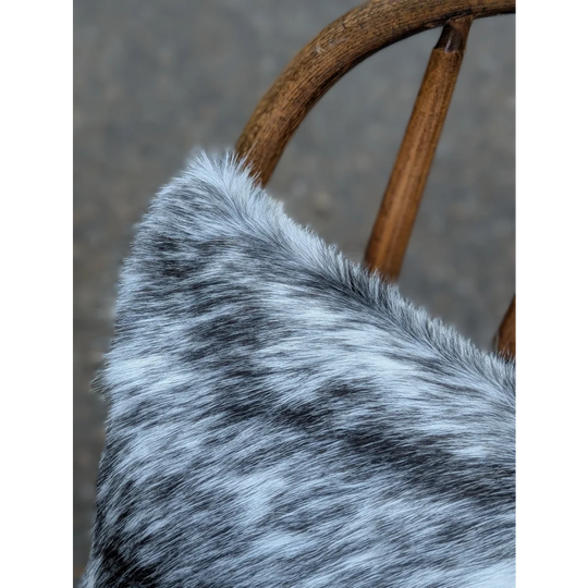 A plush gray and white double sided cowhide cushion with soft textured fur from mini moo double collection