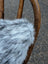 A plush gray and white speckled faux fur throw showing the back side of a double sided cowhide cushion mini moo double