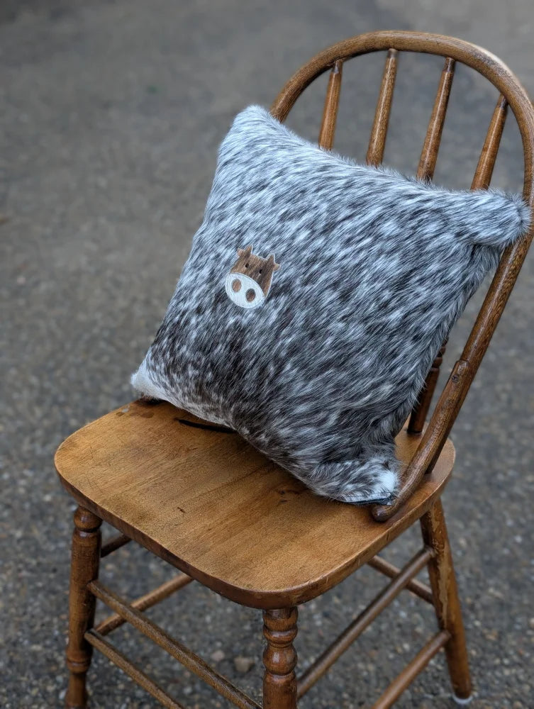 Gray and white speckled double sided cowhide cushion with a mini moo double brown pig face appliqué