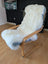 A cozy double soft sheepskin white faux fur throw oeko tex certified draped over a light wood rocking chair with blue cushions