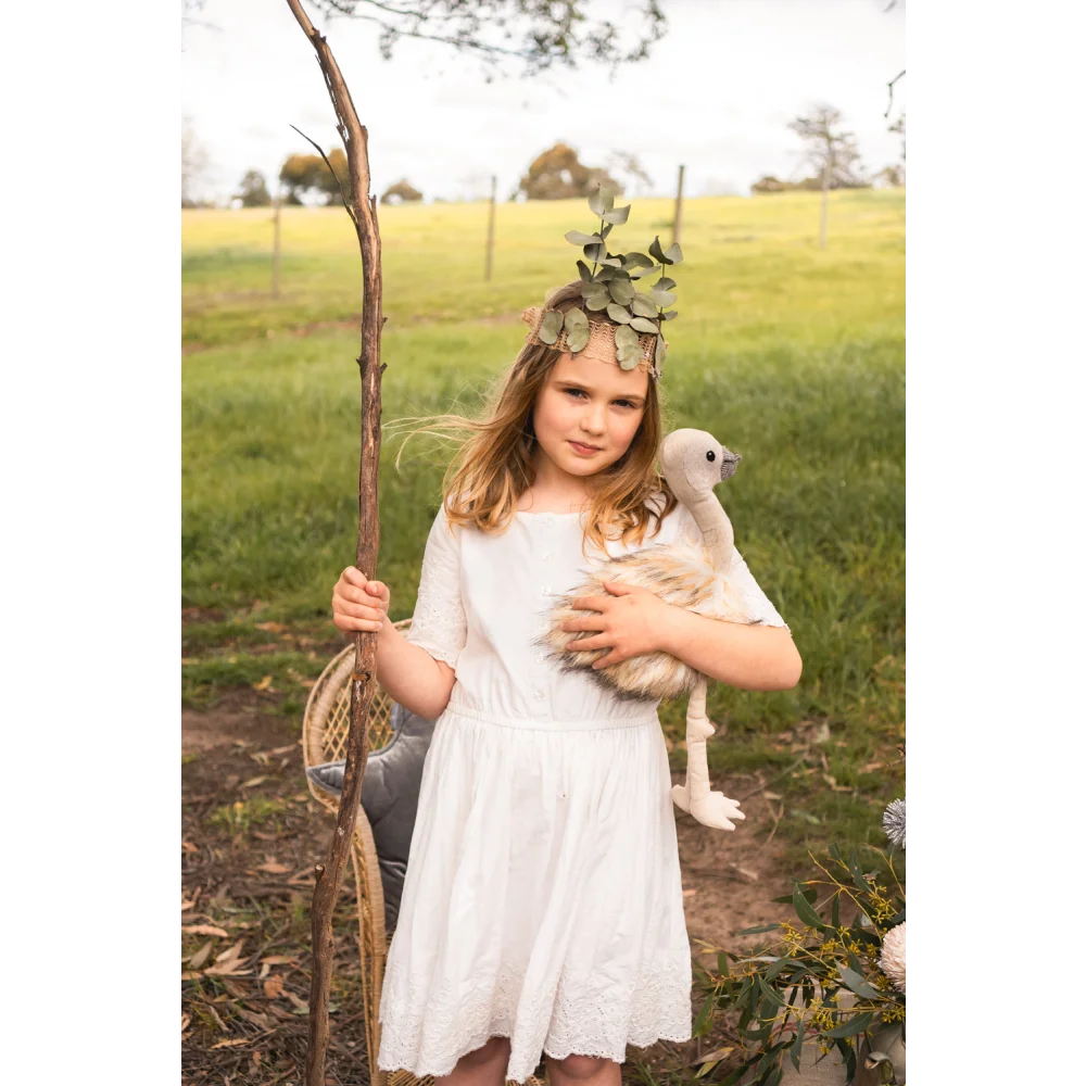 White lace dress with floral crown, wooden stick, and Angus Oliver sheepskin rug