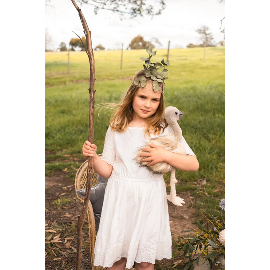 White lace dress with floral crown, wooden stick, and Angus Oliver sheepskin rug