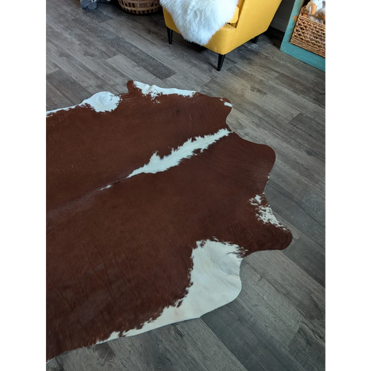 Large brown and white cowhide rug with natural irregular edges perfect for beautiful rugs and home decor