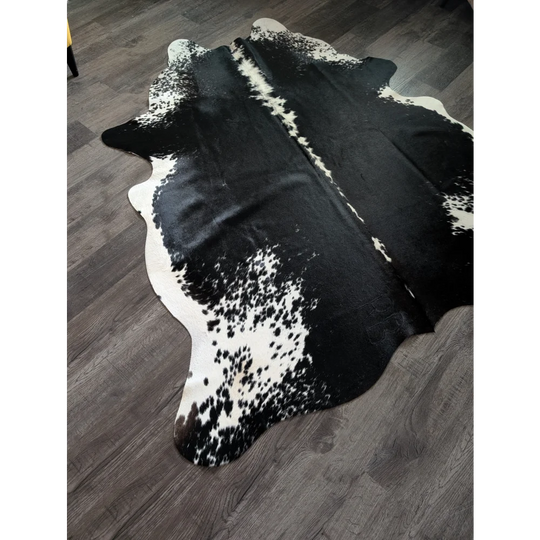 Large black and white cowhide rug with natural irregular edges perfect for adding style to any room