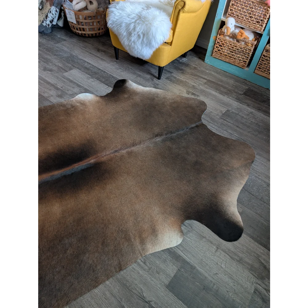 Large brown and white cowhide rug with natural fur texture perfect for beautiful rugs and home decor