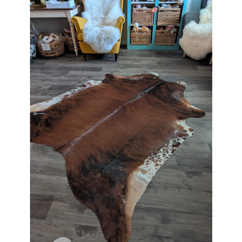 Large brown and white cowhide rug with natural irregular edges perfect for beautiful rugs and home decor