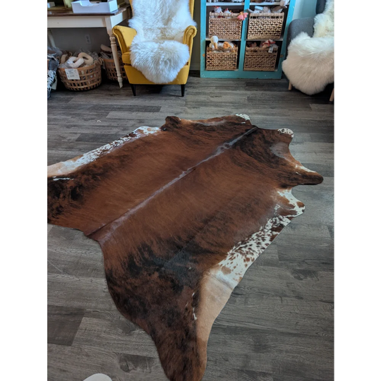Large brown and white cowhide rug with natural irregular edges perfect for beautiful rugs and home decor
