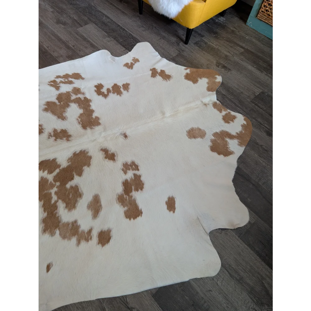 Es17 large cowhide rug in natural white and tan with spotted pattern laid on dark wood floor for beautiful rugs