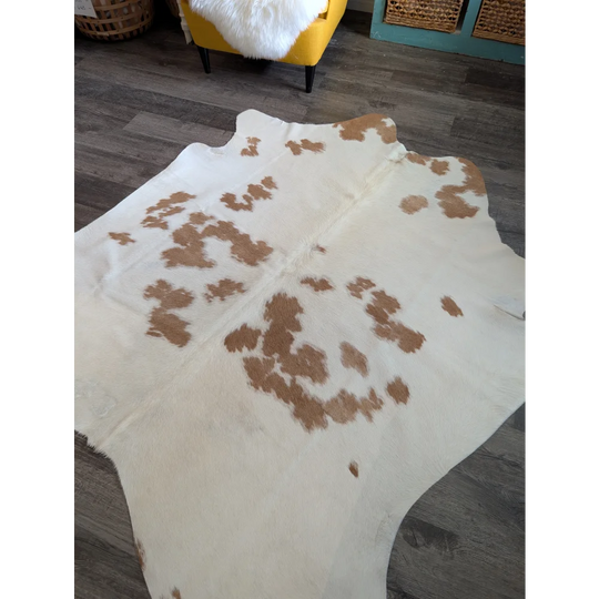 A large cowhide rug in white and brown with a natural irregular pattern perfect for beautiful rugs lovers