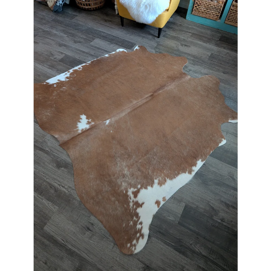 Large brown and white cowhide rug with natural irregular edges perfect for beautiful rugs and cozy spaces