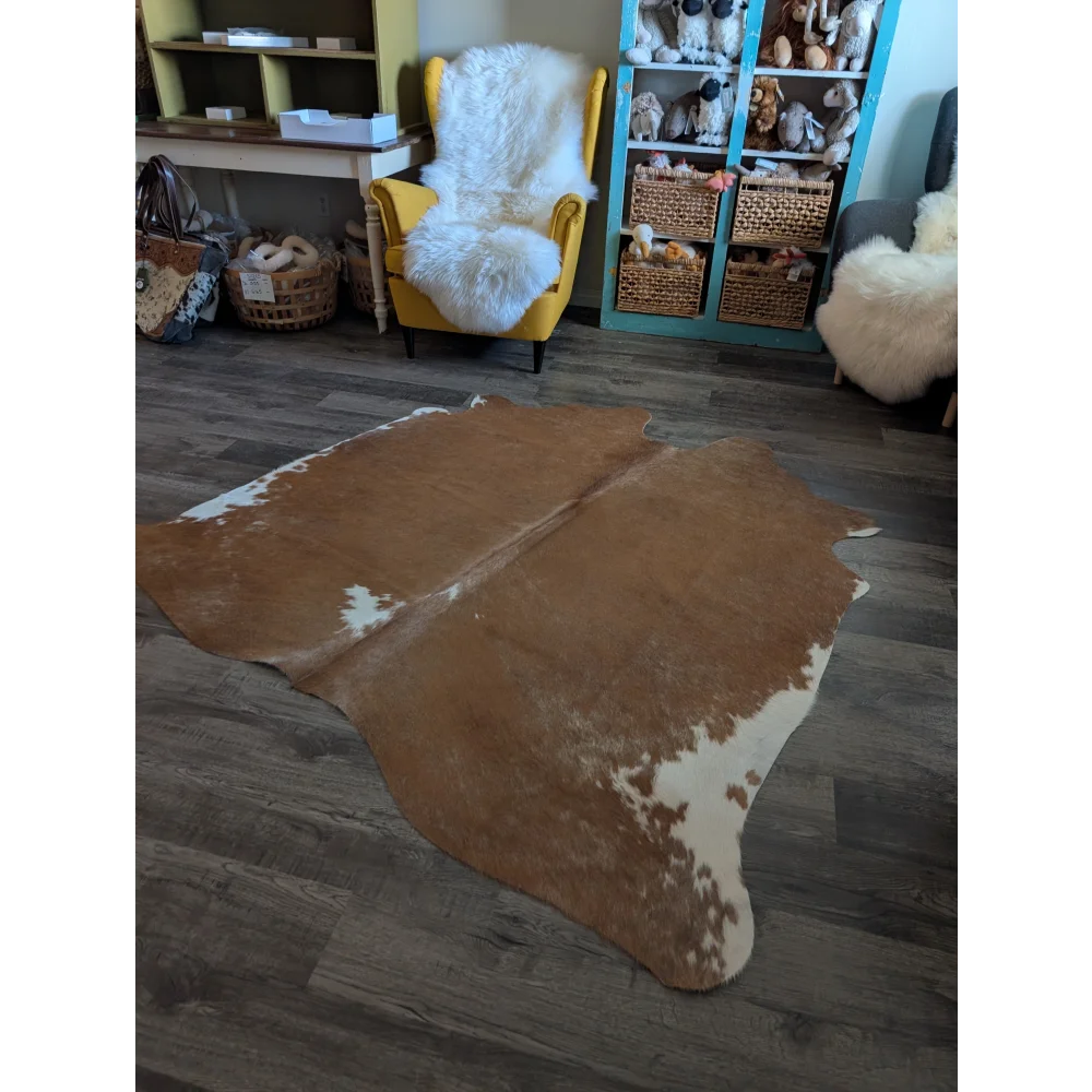 Large cowhide rug in brown and white with natural irregular edges perfect for beautiful rugs and home decor