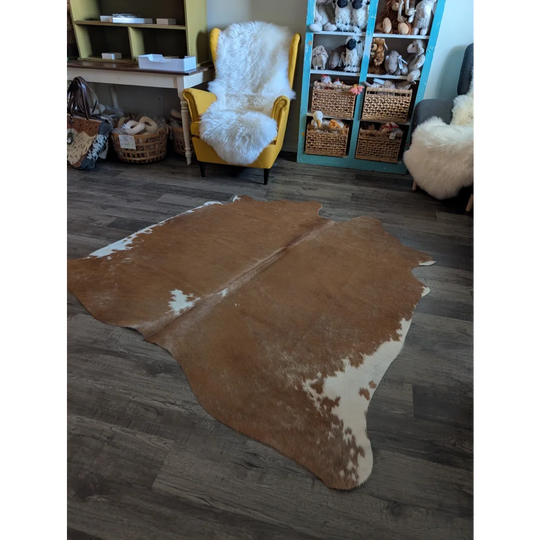Large cowhide rug in brown and white with natural irregular edges perfect for beautiful rugs and home decor
